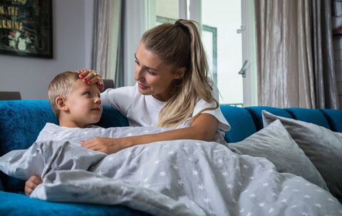 Eine Mutter legt ihre Hand auf die Stirn ihres Sohnes